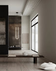Modern interior with a long vertical light fixture, minimalist decor, and a large window.
