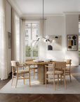 Modern dining room with wooden table and chairs, large windows, and minimal decor.