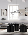 Modern living room with black coffee table, white walls, and decorative items.