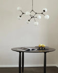 Modern dining table with a stylish pendant light in a minimalistic room.