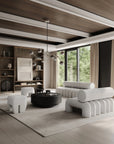 Modern living room with white sofa, coffee table, and bookshelves.