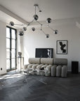 Modern living room with a chandelier, sectional sofa, and coffee table.
