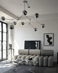 Modern living room with a chandelier, sectional sofa, and coffee table.