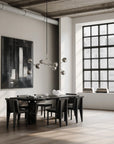 Modern dining room with a large window, black dining table, and abstract art on the wall.