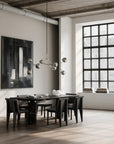 Modern dining room with a large window, black dining table, and abstract art on the wall.