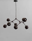 Modern black chandelier against a gray background from 101 Copenhagen available at Spacio retail stores in Mumbai & Kolkata.