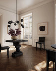 Modern interior with round black table and chairs in a well-lit room.