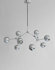 Modern chandelier with multiple spherical lights on a gray background from 101 Copenhagen available at Spacio retail stores in Mumbai & Kolkata.