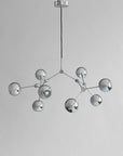 Modern chandelier with multiple spherical lights on a gray background from 101 Copenhagen available at Spacio retail stores in Mumbai & Kolkata.