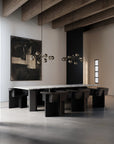 Modern dining room with black chairs and a white table, featuring abstract art and minimal decor.