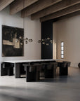 Modern dining room with black chairs and a white table, featuring abstract art and minimal decor.