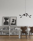 A Scandinavian theme dining room styled with books, wall art and a minimal design chandelier.