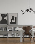 A Scandinavian theme dining room styled with books, wall art and a minimal design chandelier.
