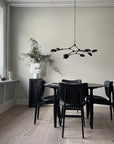 A Scandinavian theme dining room styled with sculptural vases , bowl and a minimal design chandelier.