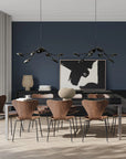 A modern theme dining room styled with 2 chandeliers, vases and wall art