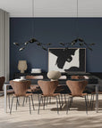 A modern theme dining room styled with 2 chandeliers, vases and wall art