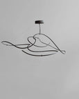 Modern black pendant light fixture on a gray background