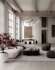 Modern living room with white sofa, gray chairs, and decorative plant.