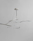 Modern pendant light with wavy design on a gray background