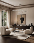 Modern living room with beige furniture, a chandelier, and large windows.