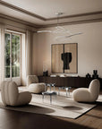 Modern living room with beige furniture, a chandelier, and large windows.