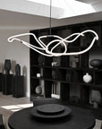 Modern chandelier hanging in a stylish room with bookshelves and decor.