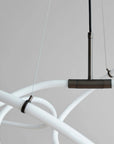 Modern chandelier with white arms and bronze fixture on a neutral background