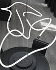 Neon light sculpture of a hand on a wooden floor