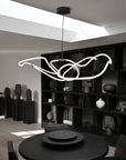 Modern chandelier hanging in a stylish room with bookshelves and decor.