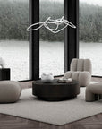 Modern living room with gray furniture and a large window view of water and trees.