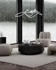 Modern living room with gray furniture and a large window view of water and trees.