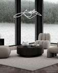 Modern living room with gray furniture and a large window view of water and trees.