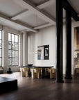 Modern interior with a dining table and chairs in a room with large windows and exposed beams.