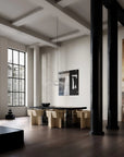 Modern interior with a dining table and chairs in a room with large windows and exposed beams.