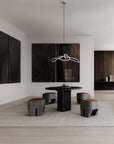 Modern dining room with black table and stools in a minimalistic setting.