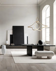 Modern interior with a black desk, white vase, and gold pendant light.