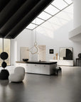 Modern kitchen with black countertops and white cabinetry, featuring a skylight.