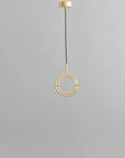 Brass pendant light fixture on a gray background