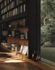 Bookshelf with books and decor next to a window with a view of greenery