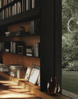 Bookshelf with books and decor next to a window with a view of greenery
