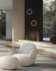 Modern white chair and ottoman in a Japandi theme room with large windows and natural light
