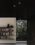 Modern interior with circular pendant lights and a bookshelf.