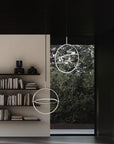 Modern interior with circular pendant lights and a bookshelf.