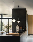 Modern Scandinavian theme kitchen with black walls, wooden cabinets, and pendant lights.