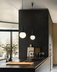 Modern Scandinavian theme kitchen with black walls, wooden cabinets, and pendant lights.