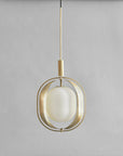 Modern pendant light with brass fixture and white glass shade on a gray background