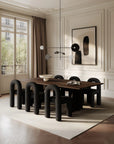 Modern dining room with a wooden table and black chairs in a stylishly decorated room.
