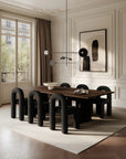 Modern dining room with a wooden table and black chairs in a stylishly decorated room.