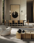 Modern living room with a white armchair, wooden coffee table, and dining area.