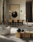 Modern living room with a white armchair, wooden coffee table, and dining area.
